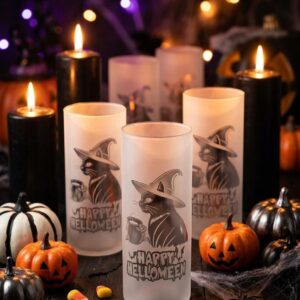 Three frosted glass vases etched with a cat in a witch hat beside a mug and "Happy Halloween" lettering, among lit candles, pumpkins and candy corn